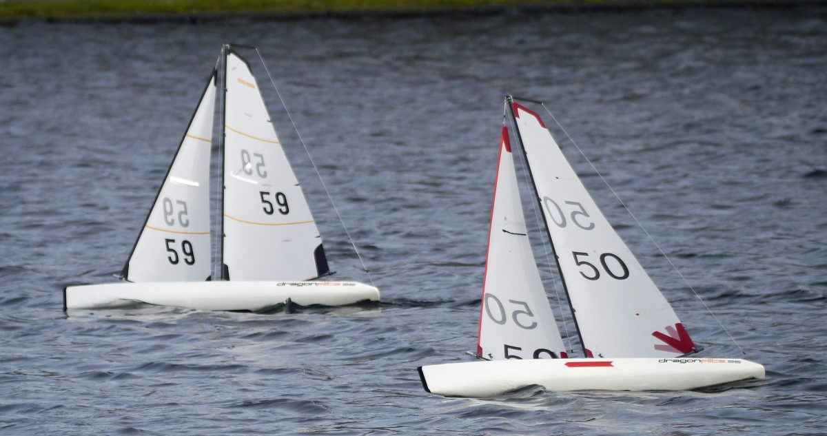 Two DragonFlite 95 radio controlled sailboats side by side, their class name visible along the hulls